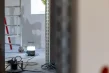 Blick durch eine Türöffnung in den nächsten Raum, Baustrahler und Kabeltrommel